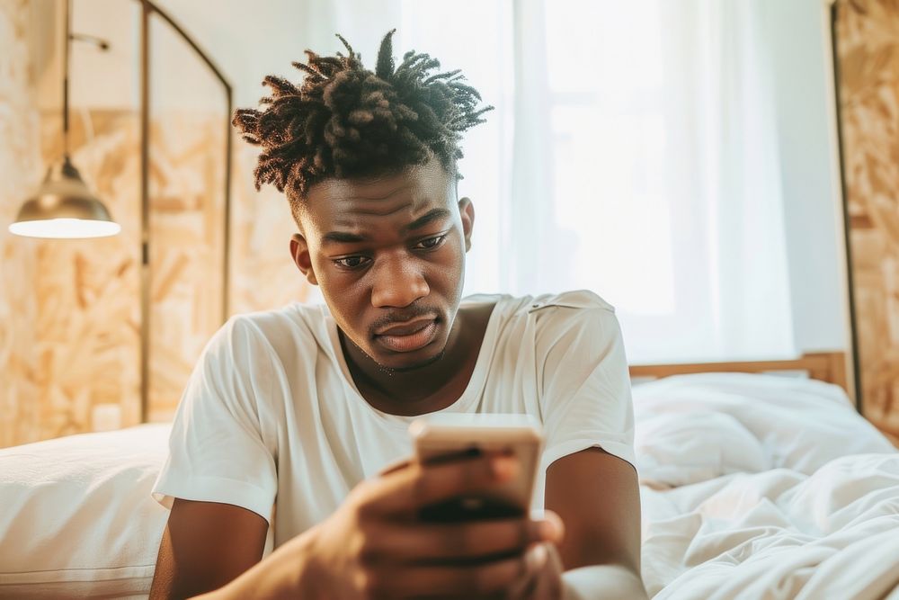 African American young man bedroom mobile phone portability.