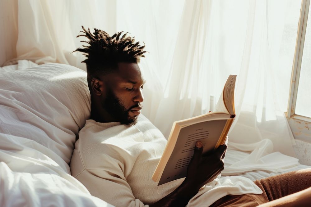 African American young man reading book publication.