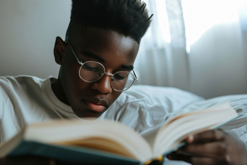 African American young man reading glasses book.