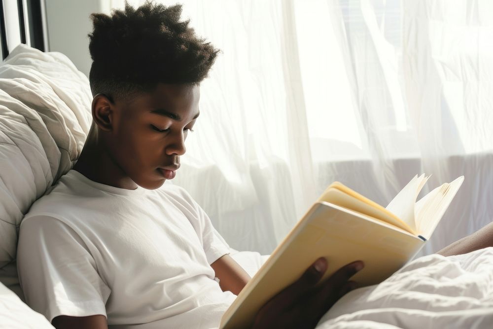 African American young man reading book publication.