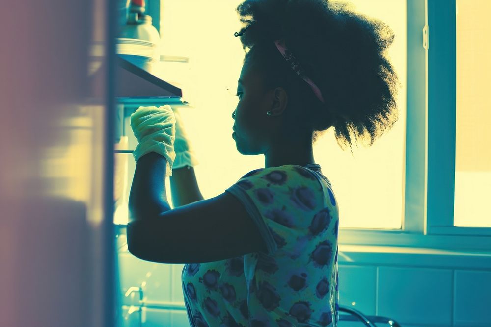 African American young woman cleaning kitchen hairstyle.