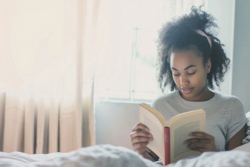 African American young woman reading book publication.
