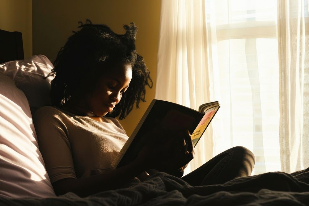 African American young woman reading bedroom adult.