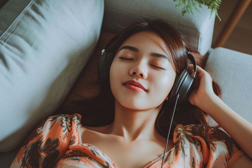 East asian female listening music happy.