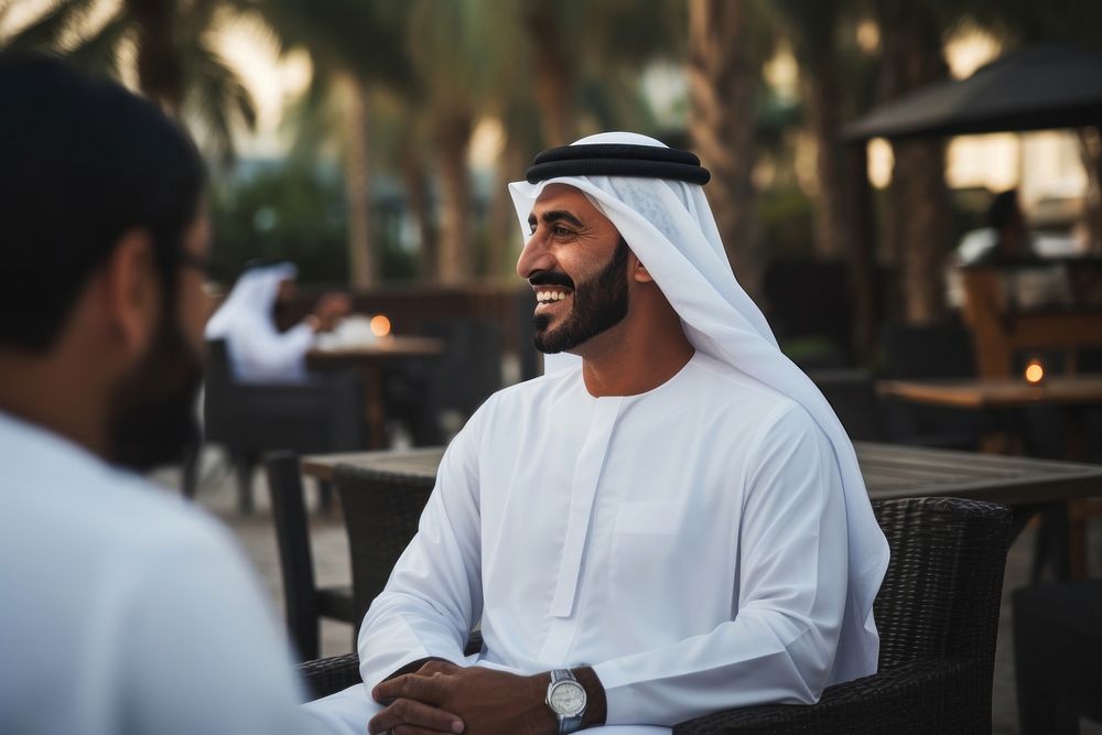 Middle eastern man in thawb talking with someone outdoors people adult.