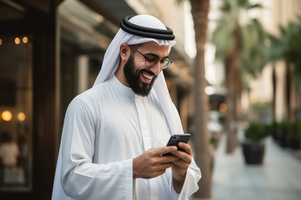 Middle eastern man in thawb typing on his smartphone outdoors people adult.