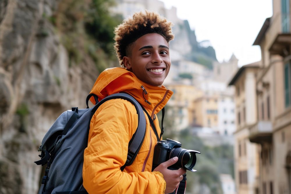 Mixed race teen man backpack camera outdoors.