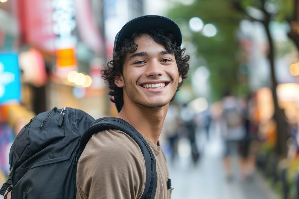 Mixed race teen man outdoors backpack smiling.