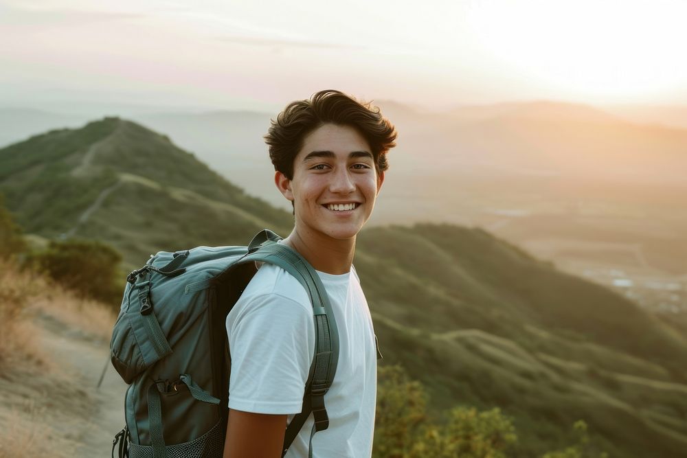 Mixed race teen man backpack mountain outdoors.