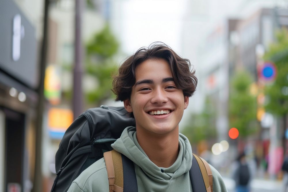 Mixed race teen man outdoors backpack smiling.