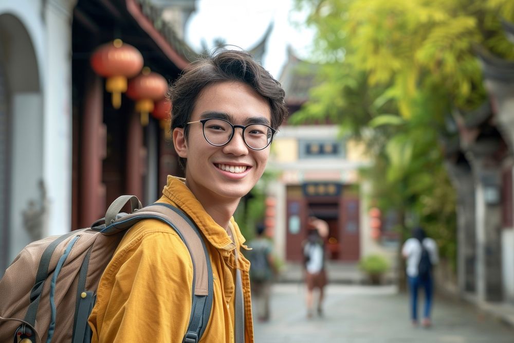 Mixed race teen man outdoors backpack smiling.