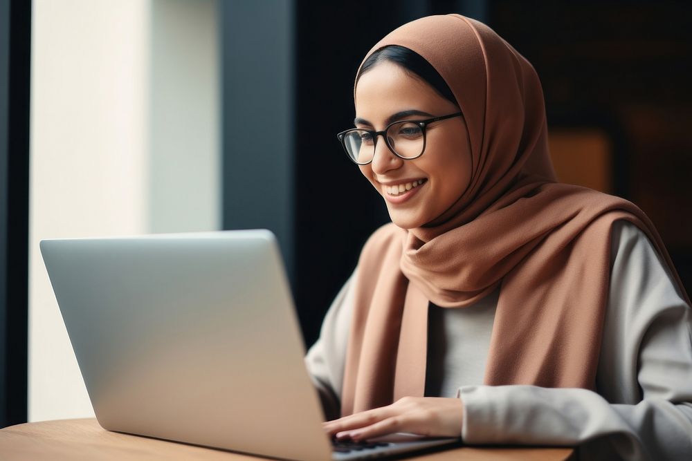 Muslim woman laptop computer glasses.