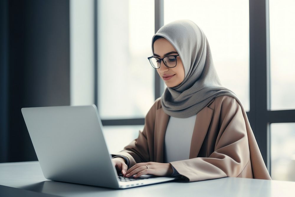 Muslim woman laptop computer glasses.