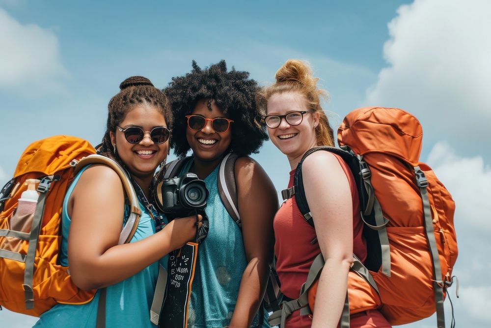 Plus size mixed race friends with backpack camera outdoors glasses.