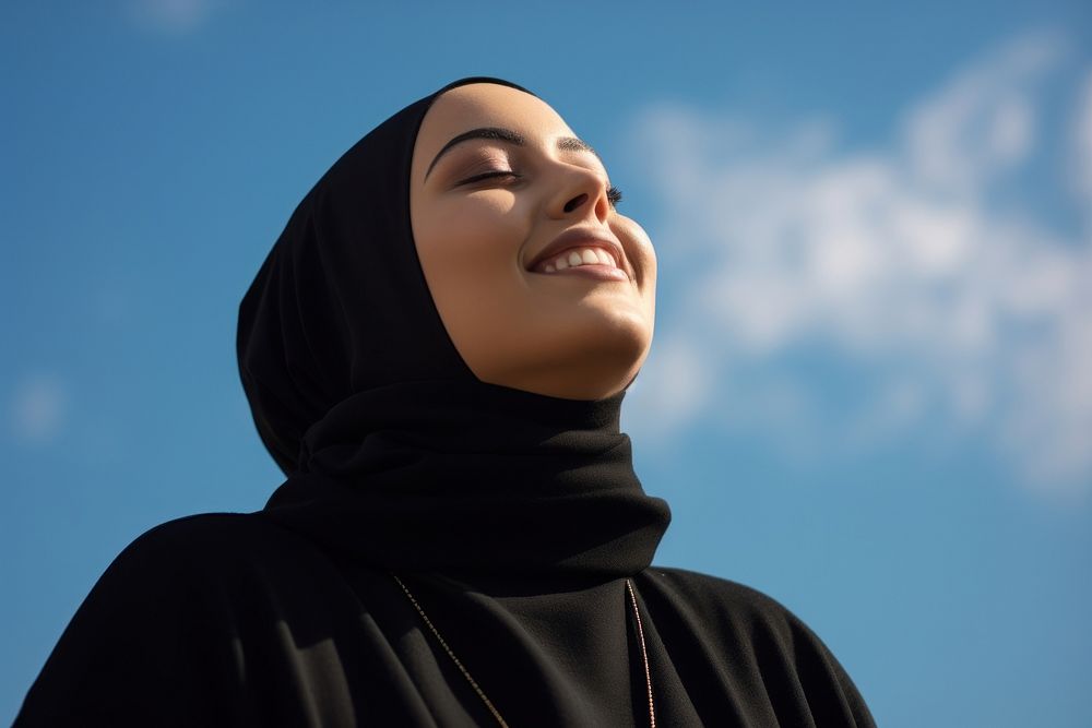 Plus size Middle eastern teen woman in abaya and hijab portrait outdoors looking.