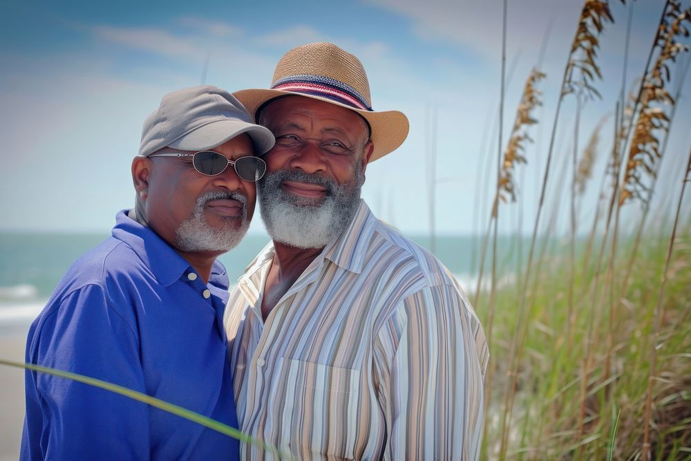 Senior Afican American gay couple beach photography sunglasses.