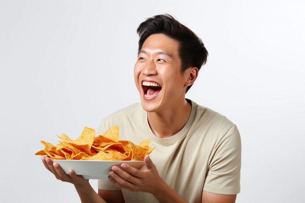 A side view of a man holding plate of chips and biting snack eating adult food. AI generated Image by rawpixel.
