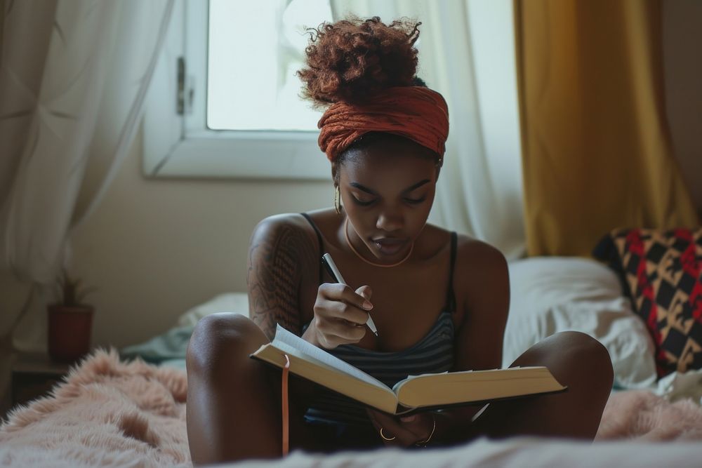 Black woman publication reading bedroom.