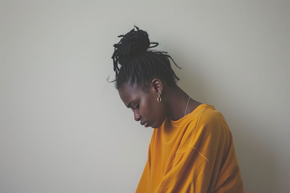 Black woman depressed contemplation dreadlocks hairstyle.