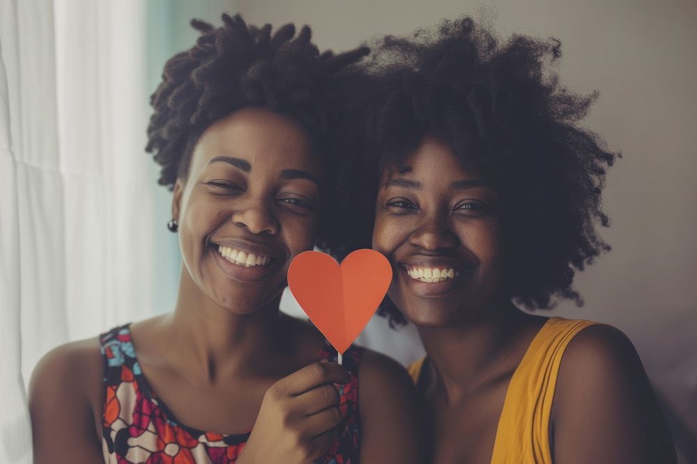 Smiling black two woman holding smile adult.