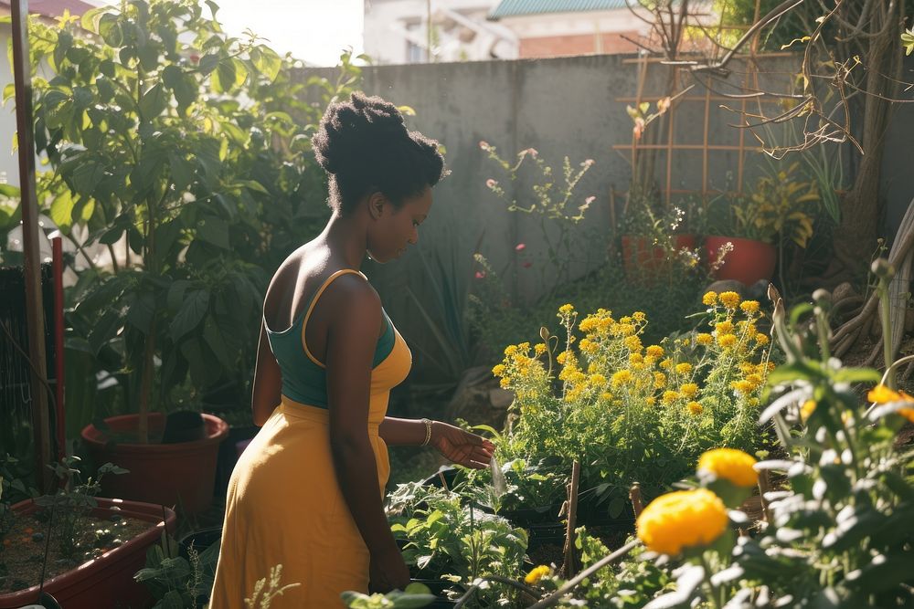 Black South African woman gardening outdoors backyard.