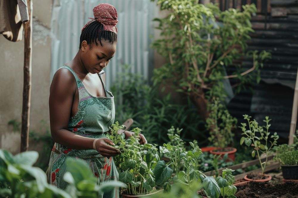 Black South African woman gardening outdoors plant.