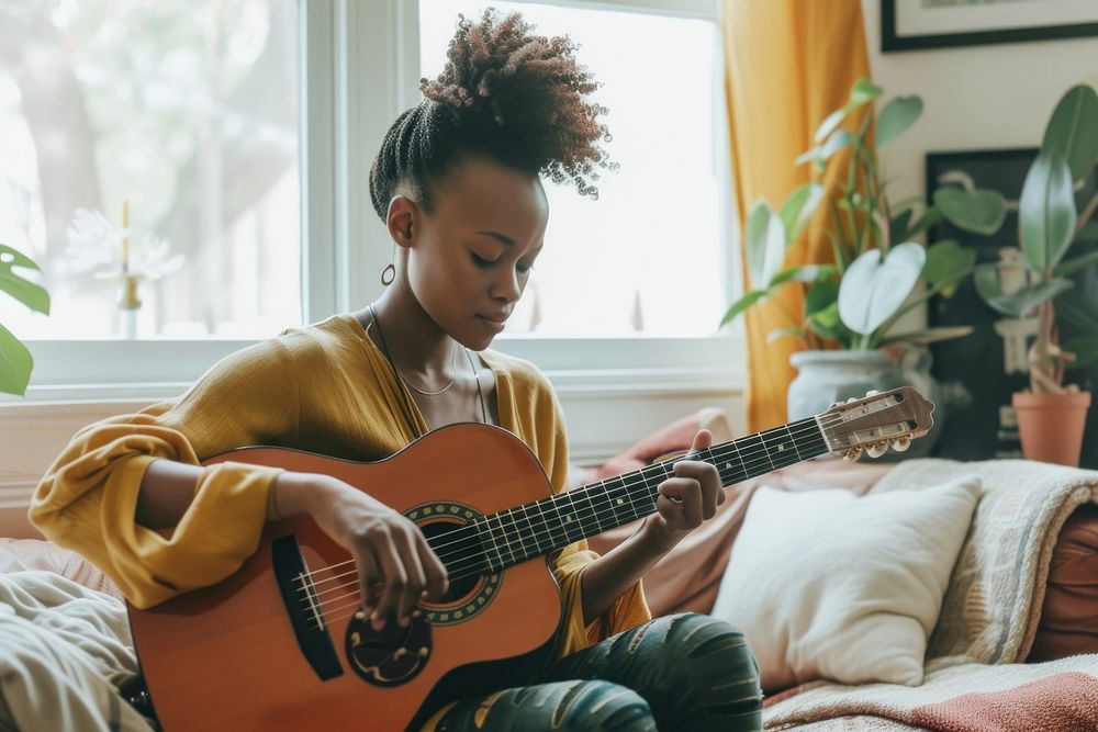 Black South African woman guitar musician playing guitar.