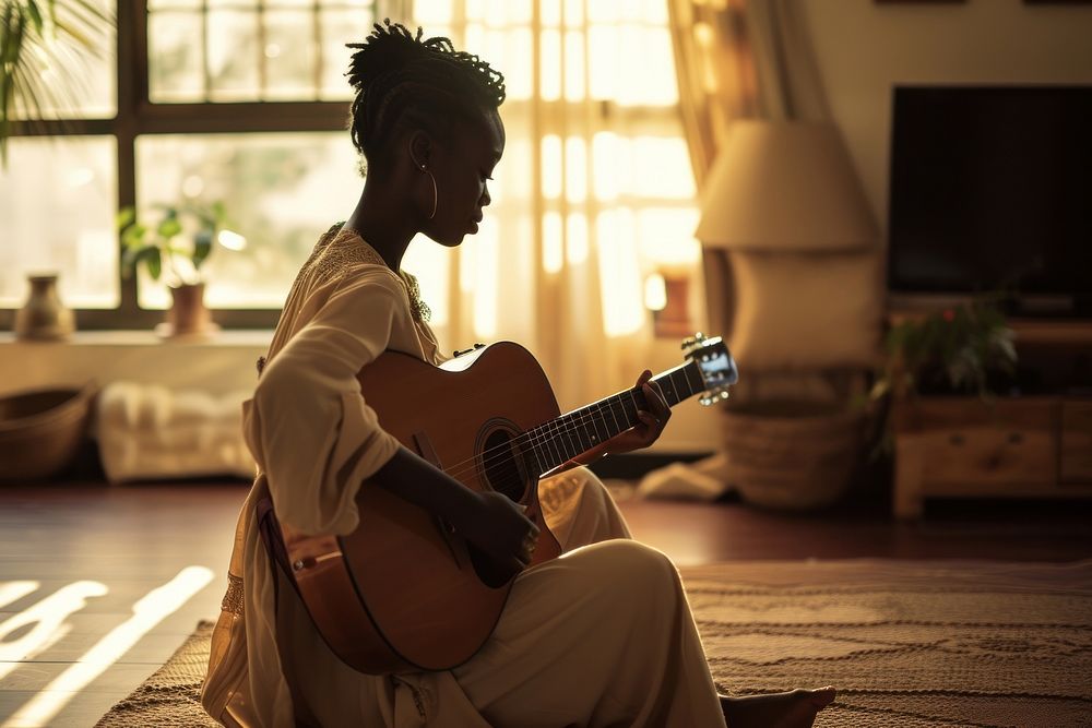 Black South African woman guitar musician sitting.
