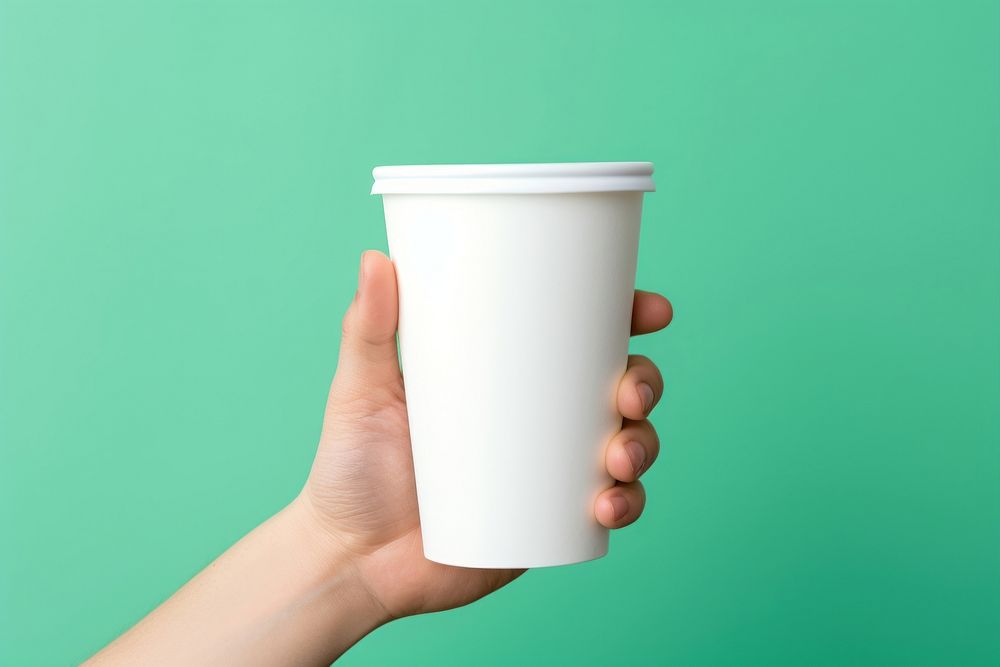 Plastic cup  holding coffee green.