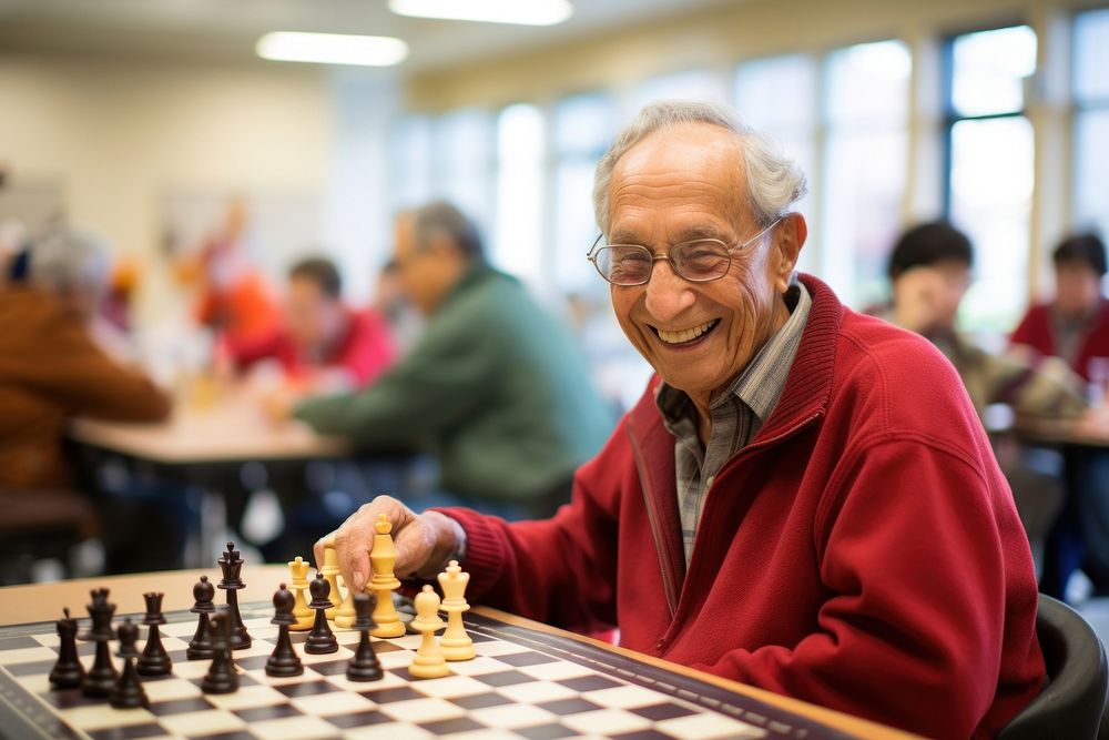 Group of seniors engaged in a lively game of chess at a community center men concentration intelligence. AI generated Image…