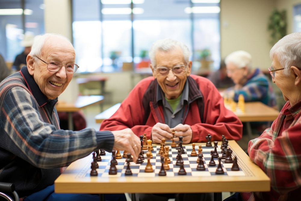 Group of seniors engaged in a lively game of chess at a community center men togetherness intelligence. AI generated Image…