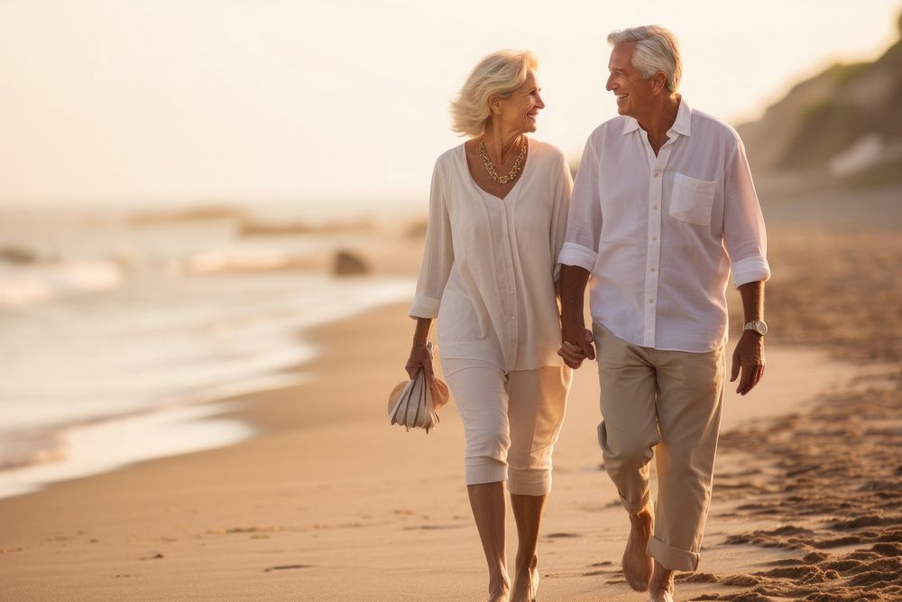 Senior couple enjoying a leisurely walk hand-in-hand by the beach walking sunset adult. AI generated Image by rawpixel.