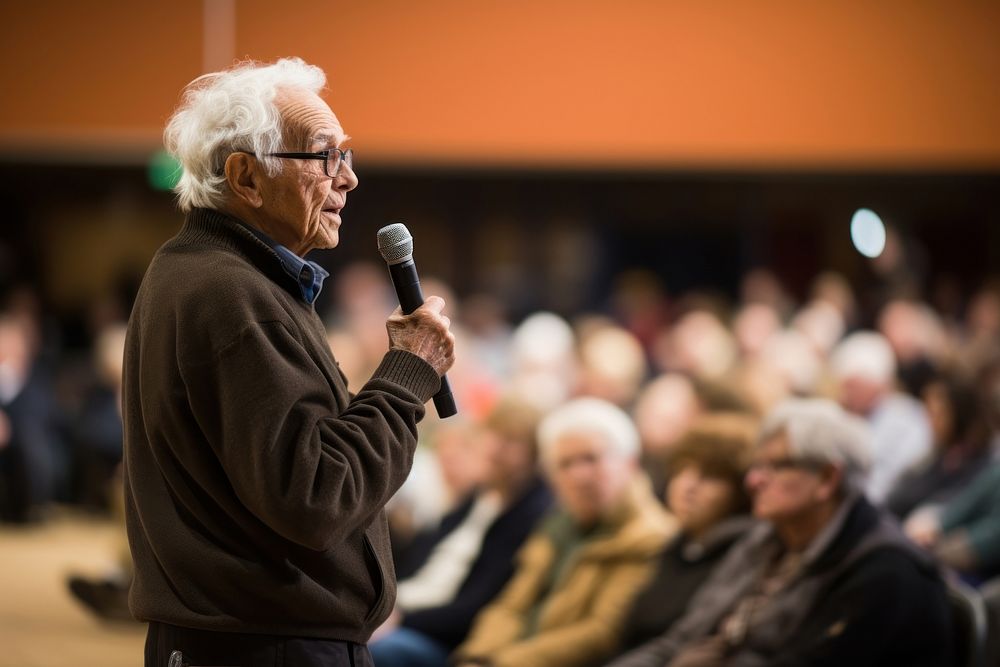 Elderly gentleman giving a motivational speech at a community event audience glasses adult. AI generated Image by rawpixel.