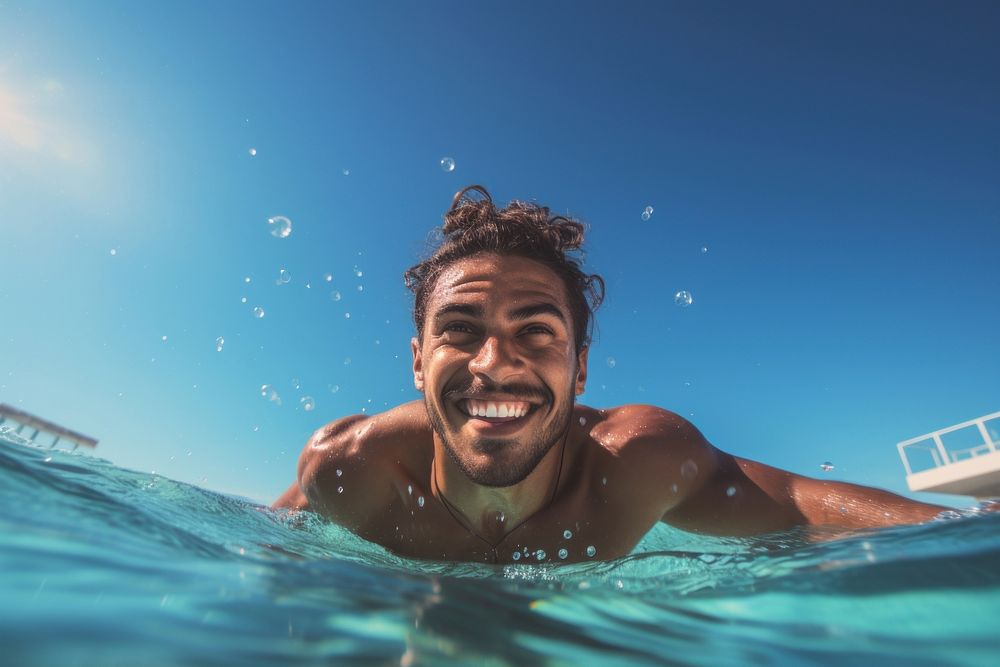Summer atractive happy Latino man swimming with goggles in the sea underwater recreation. 
