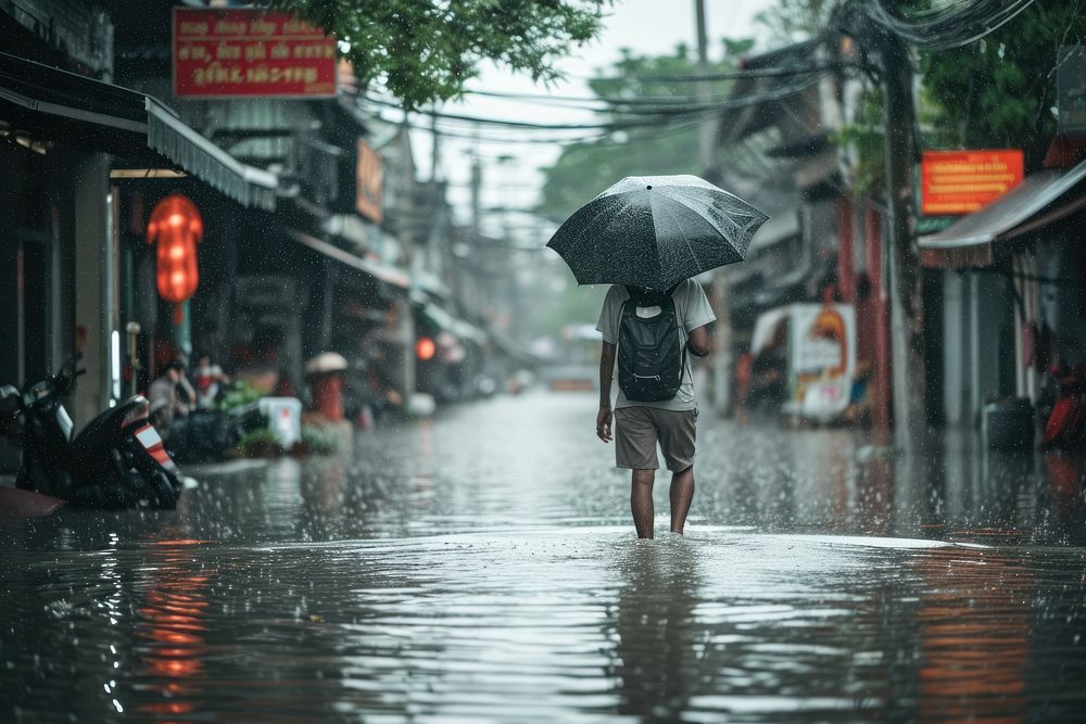 Man holding umbrella and walking while raining flood transportation architecture. AI generated Image by rawpixel.