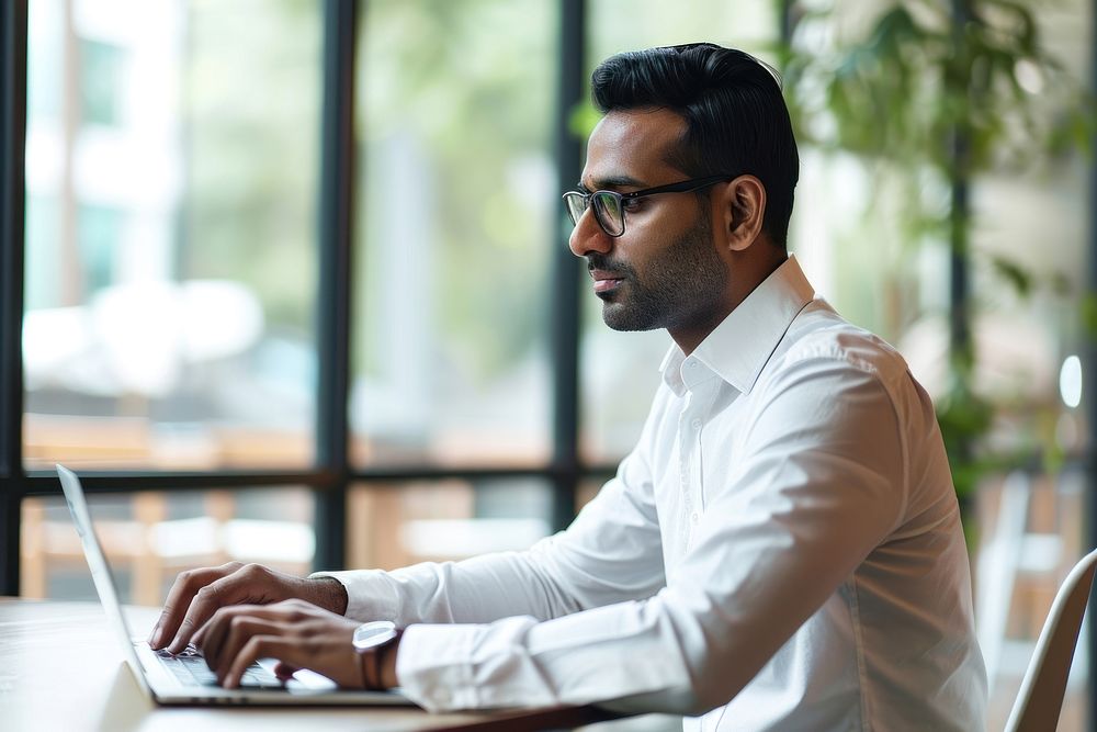 Indian businessman using laptop computer adult concentration. AI generated Image by rawpixel.