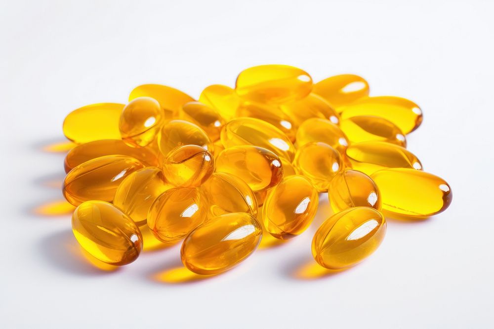 Fish oil capsules yellow pill white background.