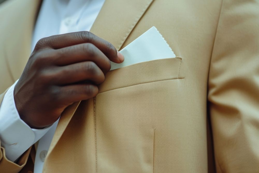 Black man in suit hiding a ticket adult hand midsection.