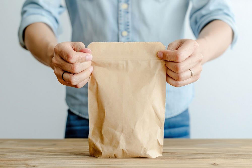 Person holding paper coffee bag hand midsection cardboard.