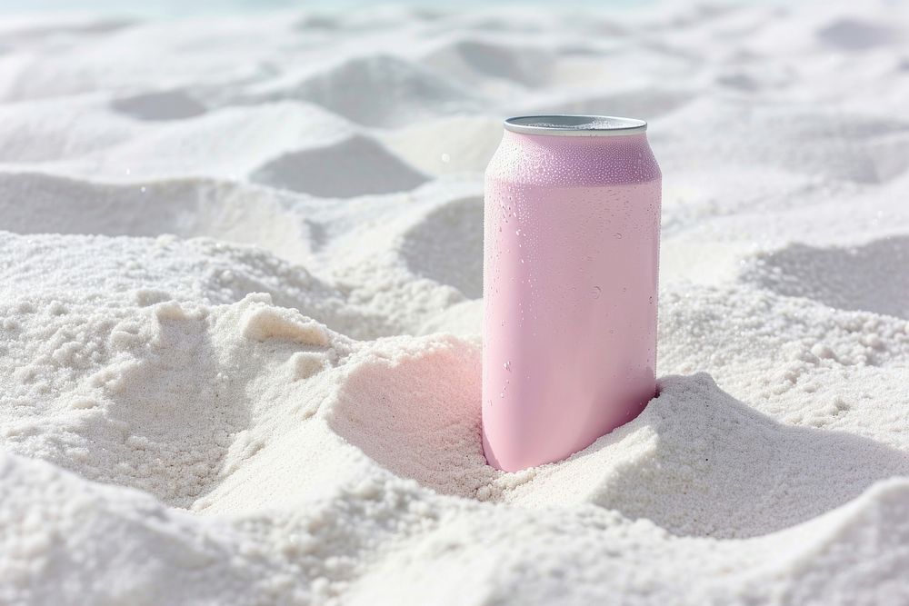 Drink can partially buried in white sand outdoors beach sea.