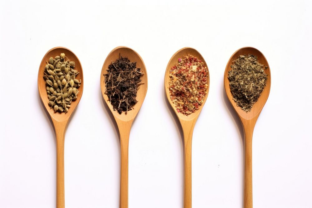 Top view of four old spoons with spices and herbs food white background ingredient.
