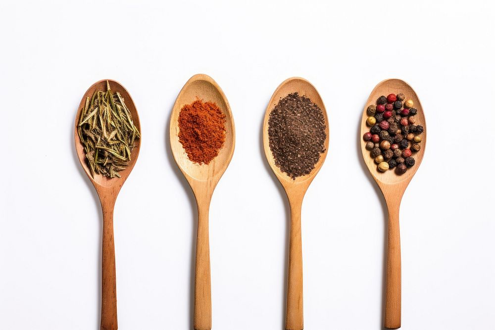 Top view of four old spoons with spices and herbs food white background ingredient.