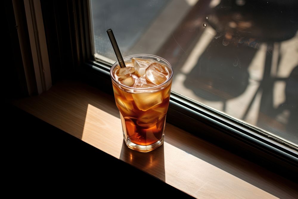 A window with iced coffee in it glass cocktail drink.