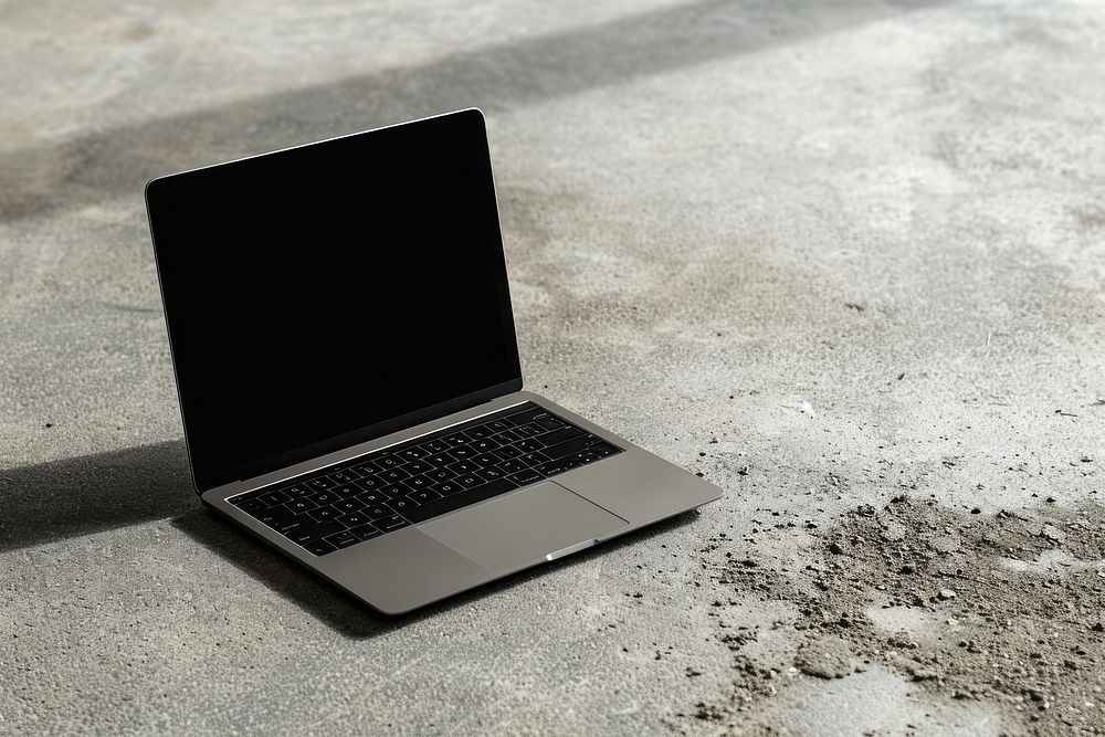Black laptop on concrete floor computer screen portability.