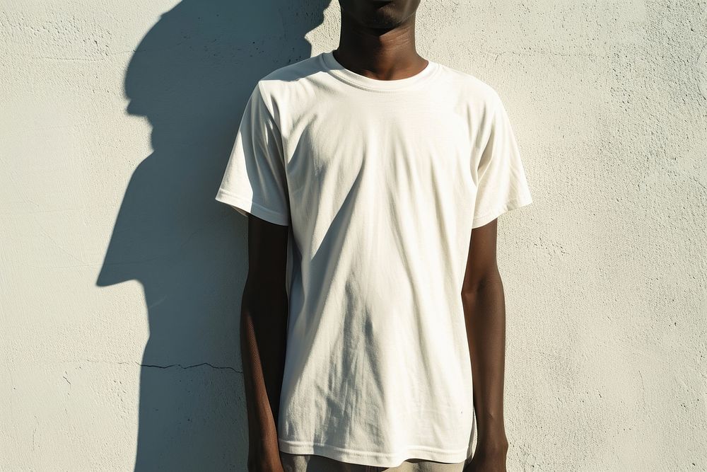 Black man wearing t-shirt standing with clean concrete background sleeve white undershirt.
