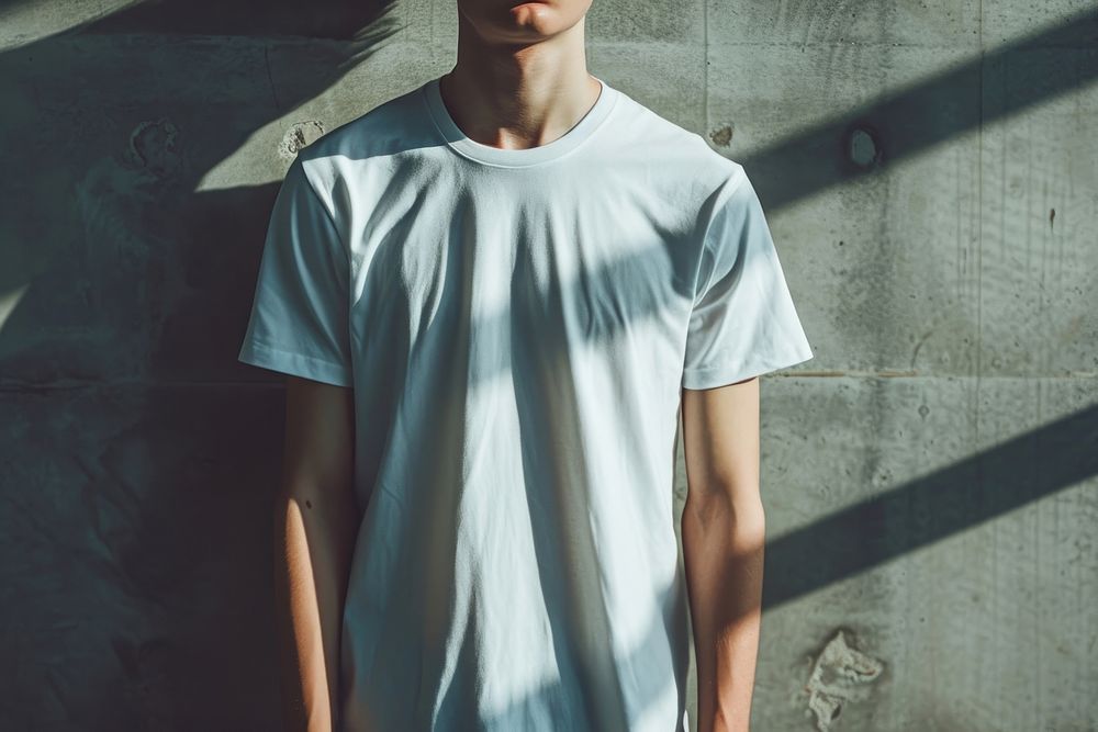 Man wearing t-shirt standing with clean concrete background sleeve white architecture.