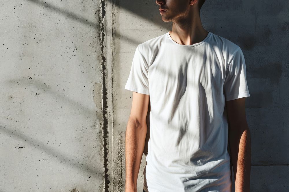Man wearing t-shirt standing with clean concrete background sleeve white architecture.