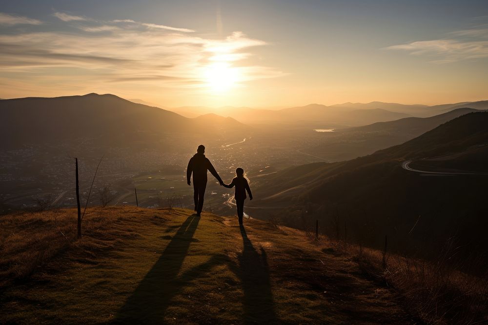 Tourists holding hand on the hill in the sunrise landscape outdoors walking.