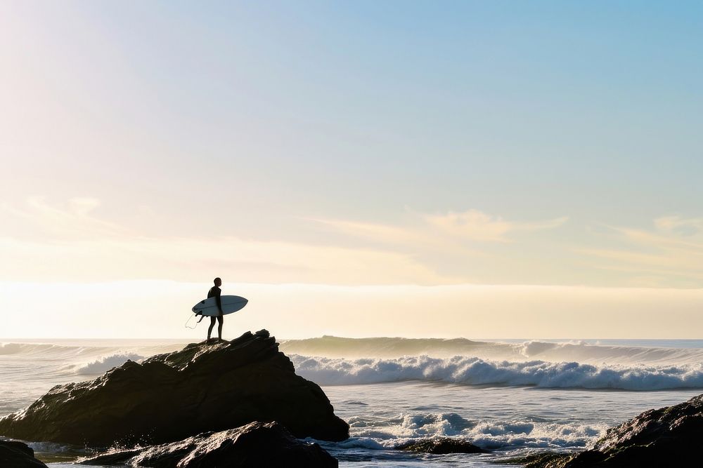 Surfer on rock looking at ocean outdoors horizon nature.