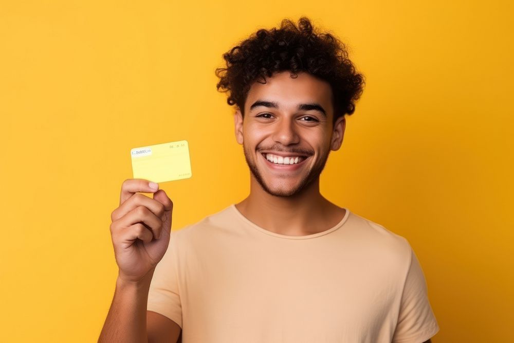 Young latin man smiling holding yellow.